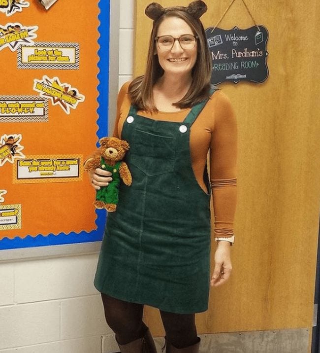 Book Character Costume Ideas Corduroy Woman wearing green corduroy jumper and teddy bear ears, carrying a matching teddy bear (Book Character Costume Ideas)