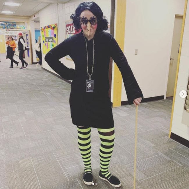 Book Character Costume Ideas Viola Swamp Woman wearing black dress, yellow and black striped stockings, and long fake nose (Book Character Costume Ideas)