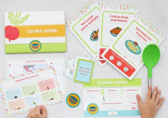 Educational Subscription Boxes Raddish Kids Child holding cooking tools and recipe cards from Raddish Kids (Educational Subscription Boxes)