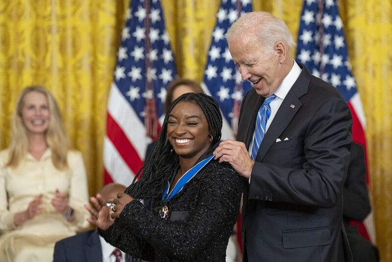 Famous People with ADHD Simone Biles receiving a medal from President Joe Biden