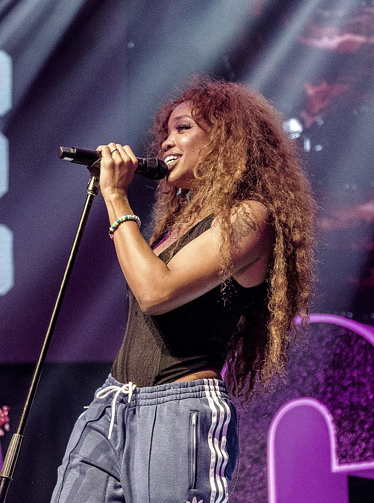 Famous People with ADHD SZA on stage with a microphone and purple chair in the background