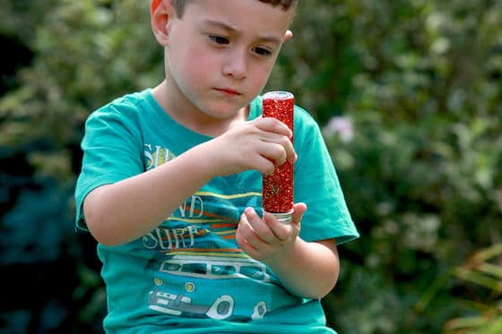 Glitter Jar A young boy is mesmerized by a bottle filled with liquid and glitter