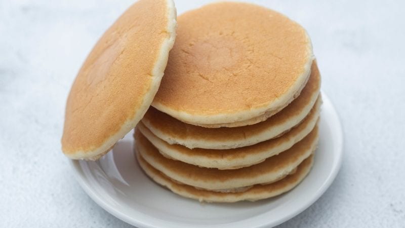 Plate of pancakes on a blue background for school breakfast club