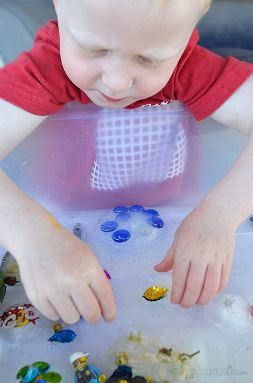 Child playing with toys frozen in ice