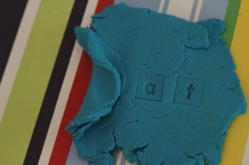 playdough-letters A flattened ball of blue play dough on a striped background