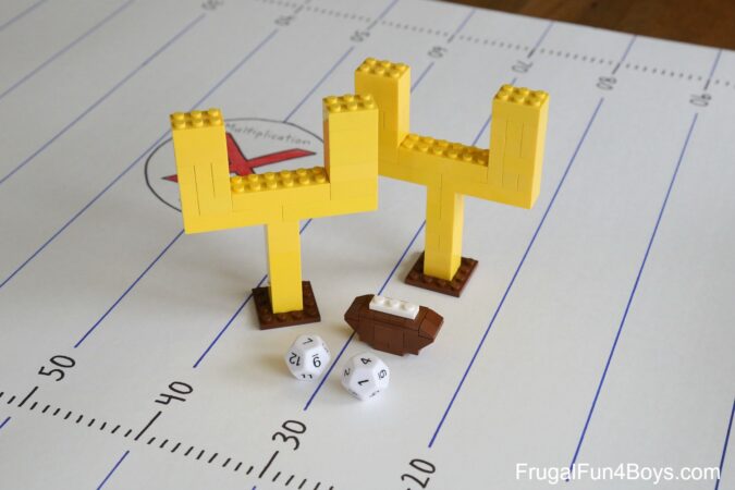 multiplication-football A pair of leg goal posts, a lego football and a pair of dice on top of a worksheet