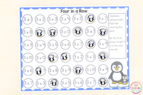 multiplication-four-in-a-row A worksheet with many circles with multiplication problems in them, a few covered with penguin stickers