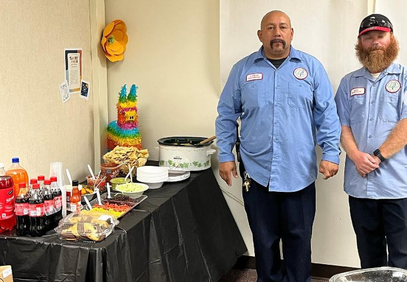 National Custodian Day Lunch School custodians standing by a nacho bar set up for National Custodian Day