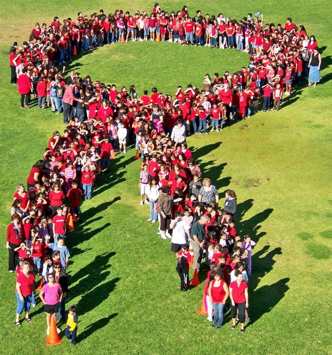 Red Ribbon Week Ideas: Group Photo Students and teachers wearing red posing in the shape of a red ribbon, photographed from above (Red Ribbon Week Ideas)