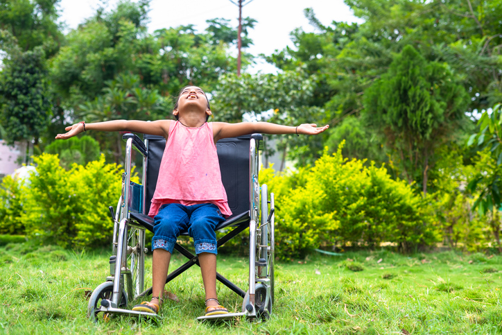 Student Stretching A girl in a wheelchair stretches her arms wide and tilts her head to the sky