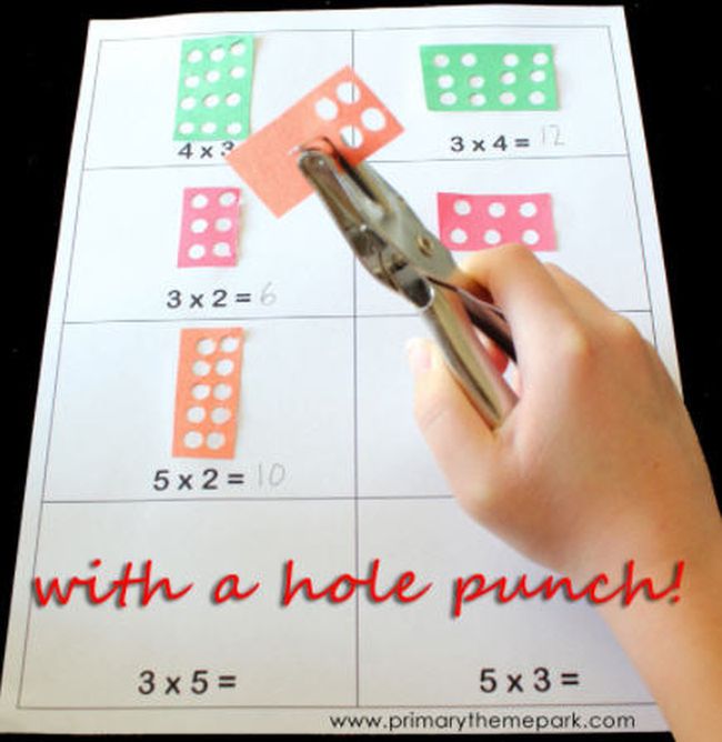 multiplication-hole-punch Student using a hole punch to make multiplication arrays on rectangles of construction paper