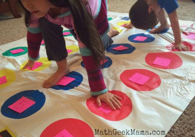multiplication-twister Kids playing Twister on a Twister mat with numbers written on each dot