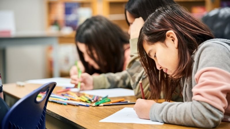 Girls drawing on desk - What Is a Museum School