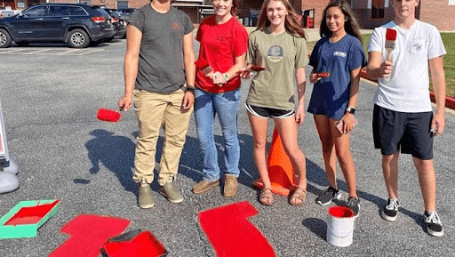 Acts of Service Students painting the concrete in this example of pep rally activities