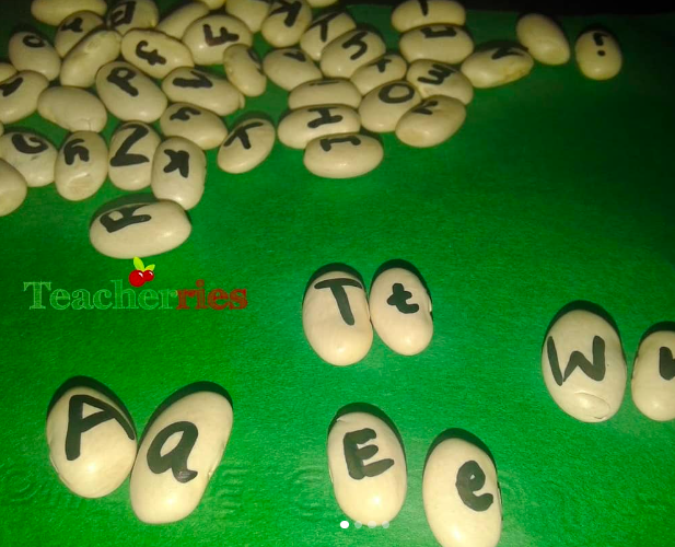 letter-beans Dried beans, each with a letter of the alphabet written on it, spread out on a green background